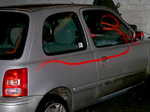 Karosserie, Fenster und Rckspiegel eines silbernen 'Nissan Micra' wurden auf der rechten Fahrzeugseite mit einer geschwungenen Linie besprht